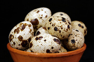 Obraz premium Quail eggs on black background, close-up shot
