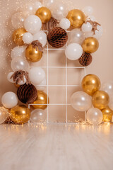 White and gold balloon arch with fairy lights, elegant festive background for event or birthday.