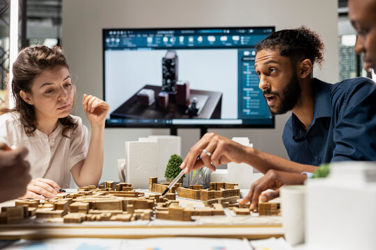 Contractors team reviews structural layout 3D models plan for urban development, balancing real estate objectives with innovation and sustainability for city planning. Site preparation.