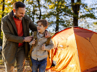 Man and son leaving camp to go hiking