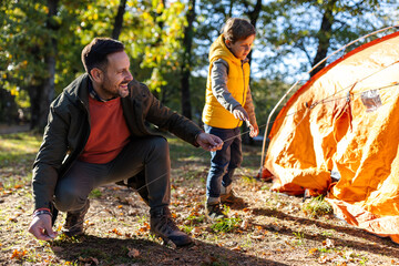 Boy helping dad set up tent