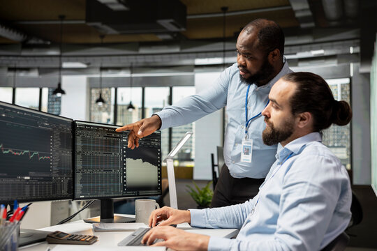 Team of risk analysts using trading platform on PC to review stock exchange volatility signs. Teamworking prop firm coworkers analyzing portfolio performance reports, checking for financial risks