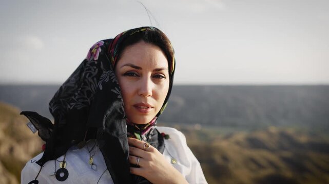 Beautiful middle eastern woman in a traditional headscarf looking at camera