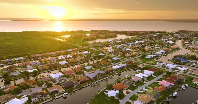 Punta Gorda, Florida at evening hour. Waterfront suburban houses and palm trees shine in warm tropical sunset atmosphere.