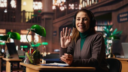 Female student joins a remote video call for an online university course, studying materials and preparing a college project in a calm study space with books and academic focus.