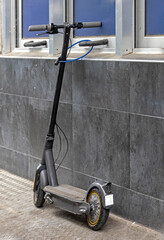 Personal electric scooter device standing outside on a street pavement