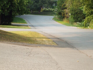 A tree-lined residential street corner in a suburban or mixed-use area