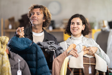 Seasonal trade sale, international couple purchase warm clothes, pick out goods. Family shopping, Latin American woman with boyfriend search and choose casual clothes. Style and fashion type look