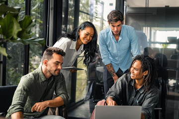 Group of young multi-ethnic startup business team collaborating on project in modern office