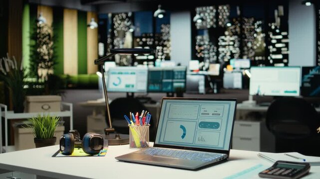 Modern business office with forecasting metrics and graphs on desk, corporate empty space equipped with technology and computers reflects administration of enterprise objectives.