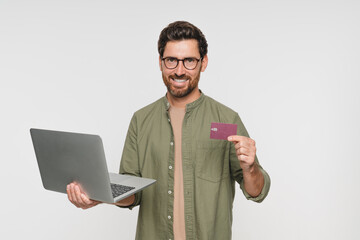 Happy man, laptop and credit card for online shopping, discount or promo isolated on studio background. Positive customer experience, ecommerce and fintech, male person and sale with mockup space