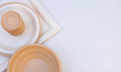 Abstract eco disposable craft plate, bowl tableware set with recycle symbol on white background.Copy space. 