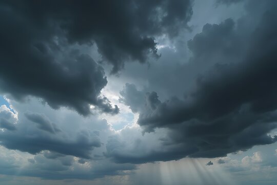 Dramatic storm clouds with sun rays peeking through the dark and ominous sky