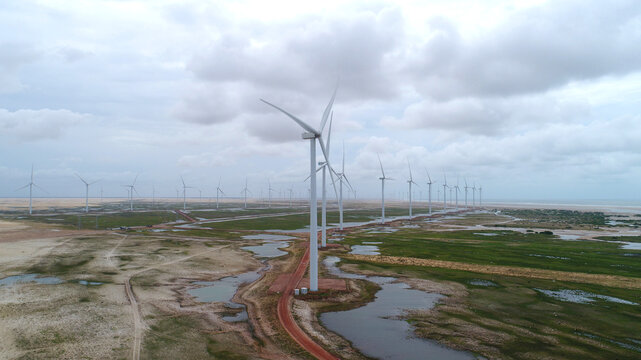 Torres e&oacute;licas entre dunas e lagoas dos Pequenos Len&ccedil;&oacute;is Maranhenses em Paulino Neves, Maranh&atilde;o, Brasil, representando energia limpa e paisagem natural