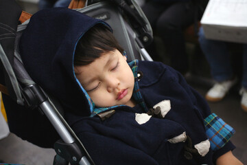 ベビーカーでぐっすりと眠っているアジアの日本人の赤ちゃん お出かけ