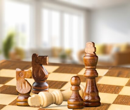 Wooden chess figures on a classic chessboard