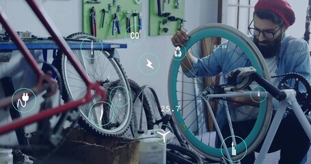 Bearded mechanic tightening spokes on turquoise bicycle wheel in workshop, with pegboard