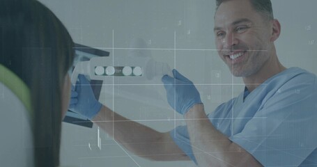 Dentist in blue scrubs positioning x-ray sensor near patient in lead apron in dental clinic