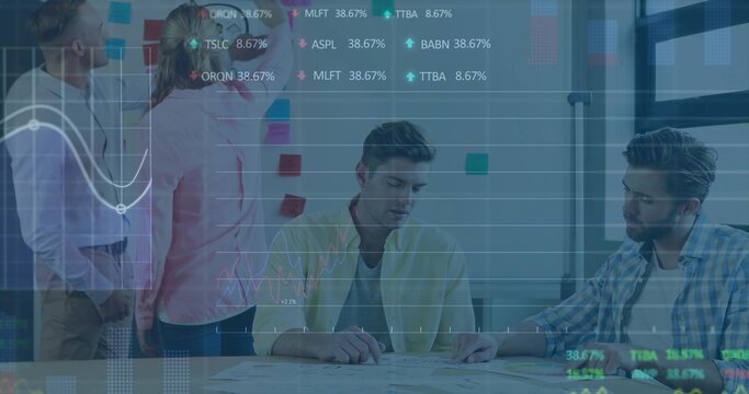 Collaborating team placing sticky notes on board and reviewing plans in office, with stock graphs