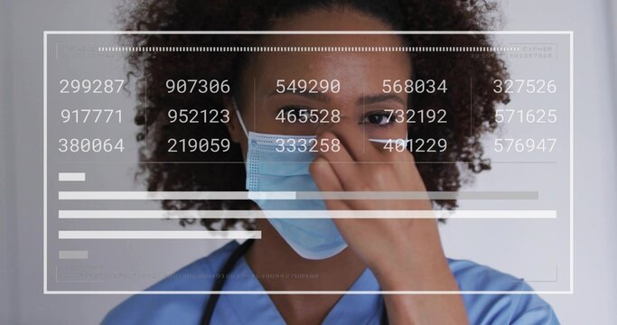 African American nurse adjusting surgical mask in clinic with scrubs, stethoscope, data graphics - Powered by Adobe
