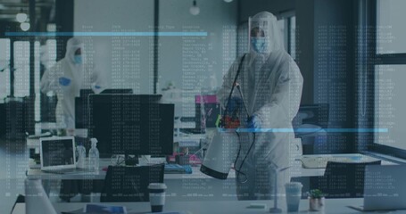 Male in protective suit spraying desks with sprayer in open-plan office, with computers, copy space