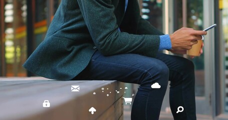 Holding coffee cup, tapping smartphone man in blazer sitting on bench at office, with digital icons