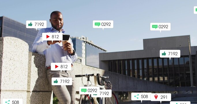 Leaning business casual man using tablet on roof ledge holding coffee with bicycle, floating icons - Powered by Adobe