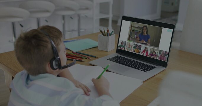 Studying boy wearing striped shirt and headset at kitchen table with laptop, pencils, copy space - Powered by Adobe