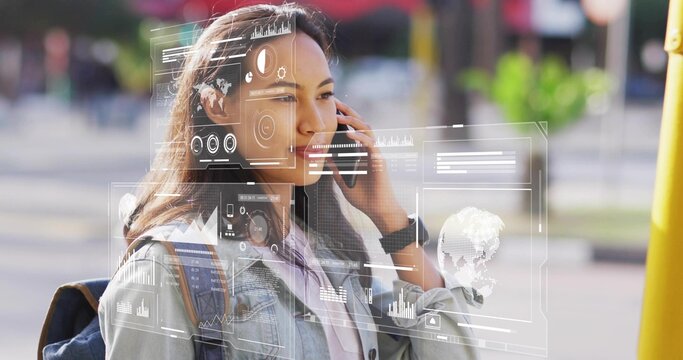 Woman accessing holographic data while talking on smartphone at city sidewalk, wearing denim jacket