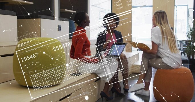 Collaborating three business women sharing ideas in lounge with orange pouf, laptop and tan folder - Powered by Adobe