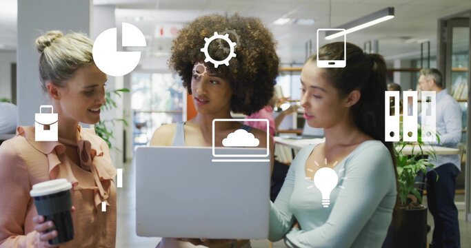 Discussing details on laptop three-woman team in open office, with coffee cup and floating icons