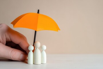 Human hand protecting wooden family figures with a small orange umbrella, symbolizing insurance, security, and care for loved ones