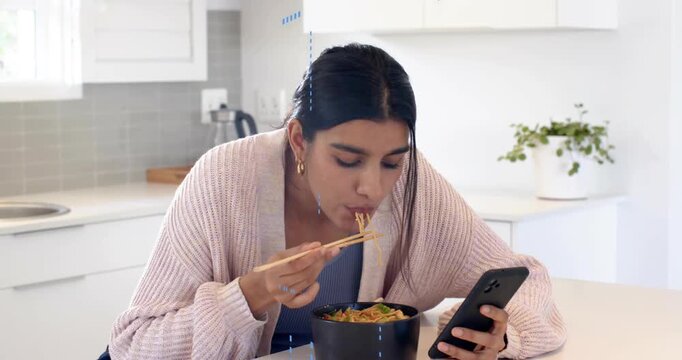 Woman stirring noodles with chopsticks scrolling phone revealing icons around bowl for food tech
