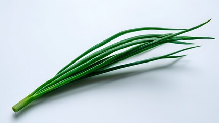 Fototapeta premium Fresh green stalks of an allium vegetable rest diagonally across a bright white surface