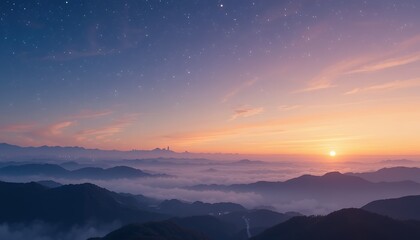 Expansive mountain ranges covered in mist under a vibrant early morning sky with the sun rising on