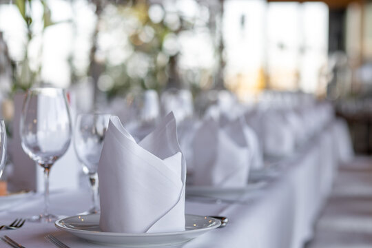 Elegant table setting in a modern restaurant with folded napkins and wine glasses ready for dining