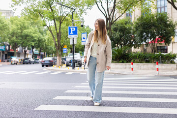 Young woman crossing a city street using a pedestrian crosswalk