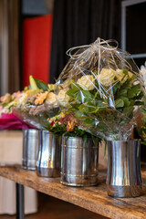 Beautifully arranged flower bouquets in clear wrapping displayed on a wooden table in a cozy indoor setting