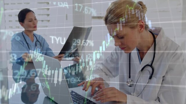Doctor typing laptop while peer holding X-ray film floating finance charts cross-referencing data