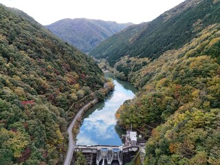 A beautiful mountain valley with a river running through it. The trees are full of leaves and the...