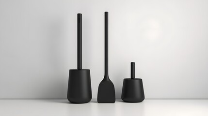 Naklejka premium Three modern matte black bathroom accessories stand side by side against a light background