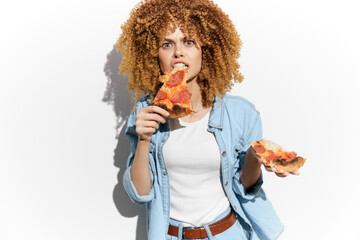 Young woman with curly hair enjoying pizza, showcasing emotions of indulgence and happiness,...