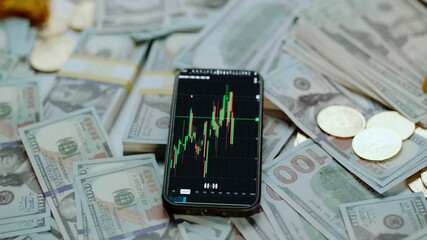Modern smartphone showing a cryptocurrency stock market exchange graph lying on a pile of cash, gold bars, and bitcoin coins, representing digital asset trading and financial investment - Powered by Adobe