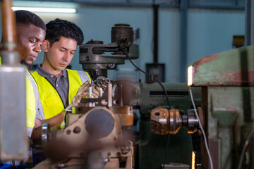 Two engineers focus on adjusting industrial machinery with precision. Teamwork, mechanical engineering, machine maintenance, technical collaboration, and industrial training.