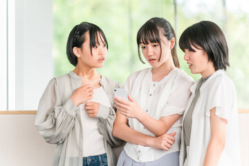 A group of elementary and junior high school girls are surprised by their smartphones
