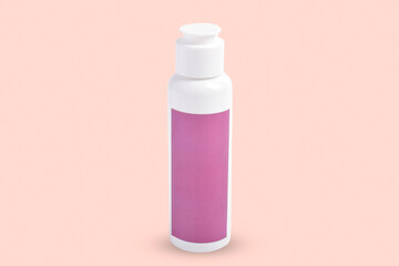 Shower gel or shampoo in clean white plastic cosmetics bottle isolated on pink background.