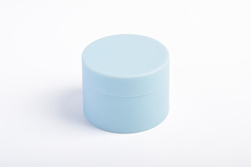 Blue cosmetic jar isolated on a white background.