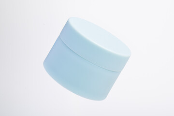 Blue cosmetic jar isolated on a white background.