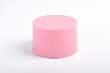Pink cosmetic jar isolated on a white background.