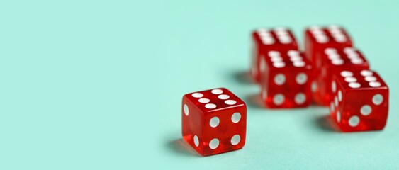 Red game dices on turquoise background with space for text, closeup
